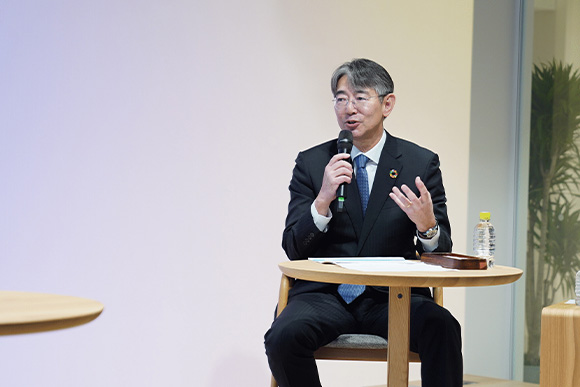 ステージ上で話をしている𠮷田潤吉